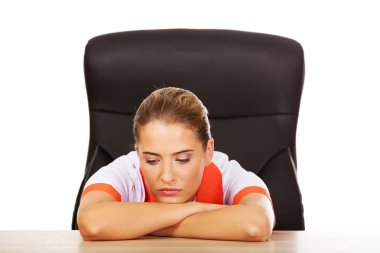 Masanın arkasında oturan yorgun genç kadın doktorunuzya hemşire