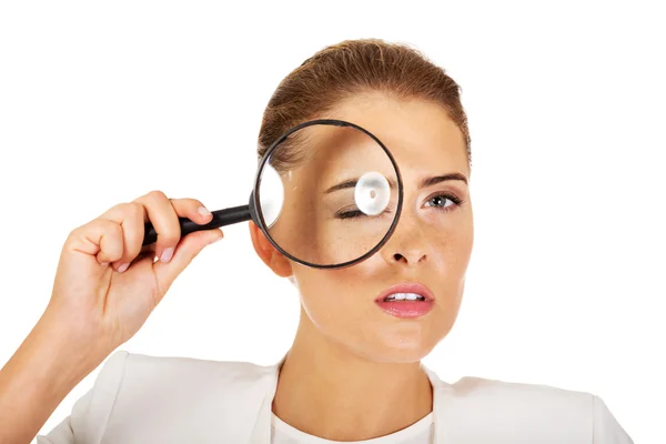 Businesswoman looking into a magnifier and have a big eye — Stock Photo, Image