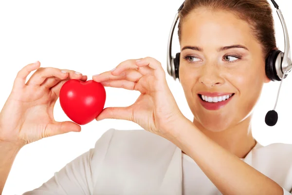Happy call center woman with heart toy — Stock Photo, Image