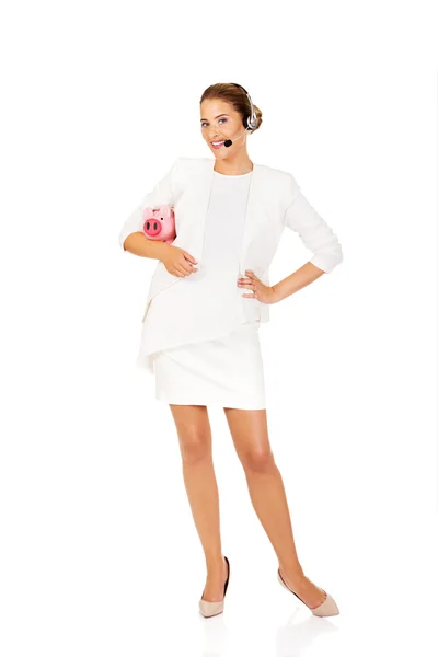ヘッドセット piggybank を保持の若い女性実業家 — ストック写真