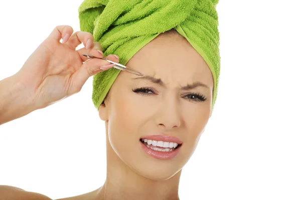 Beautiful woman plucking her eyebrow. — Stock Photo, Image