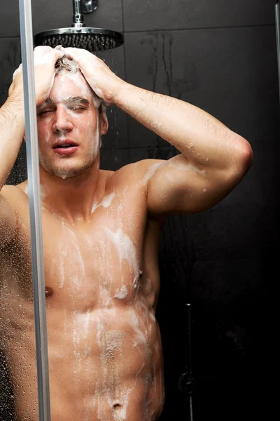 Schöner Mann wäscht sich mit Seife. — Stockfoto