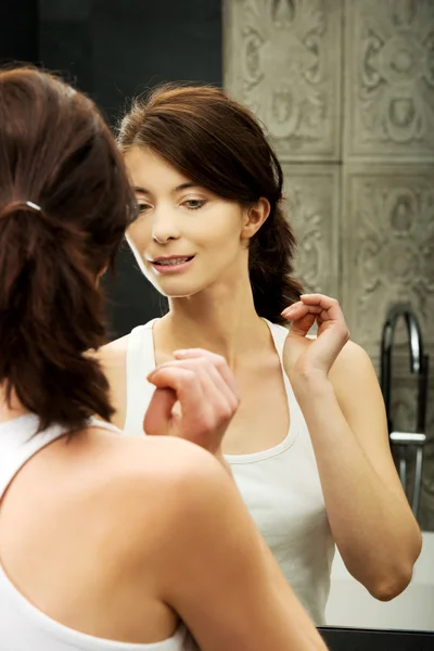 Donna mettendo crema anti-invecchiamento sul suo viso . — Foto Stock