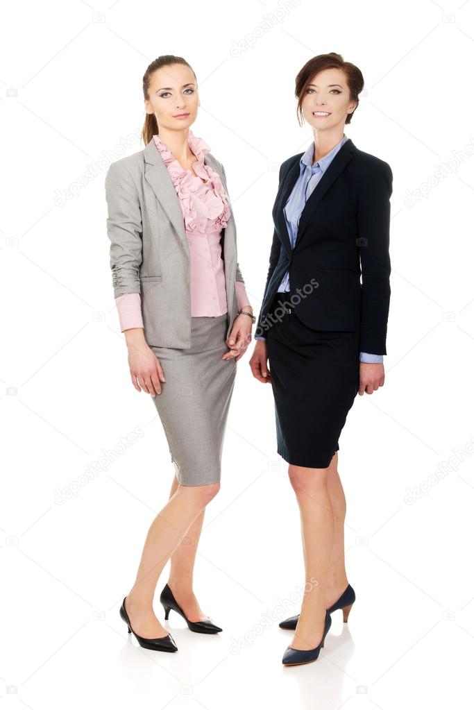 Two women wearing office outfits.