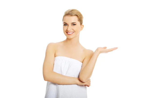 Spa woman wrapped in towel with empty hand. — Stock Photo, Image