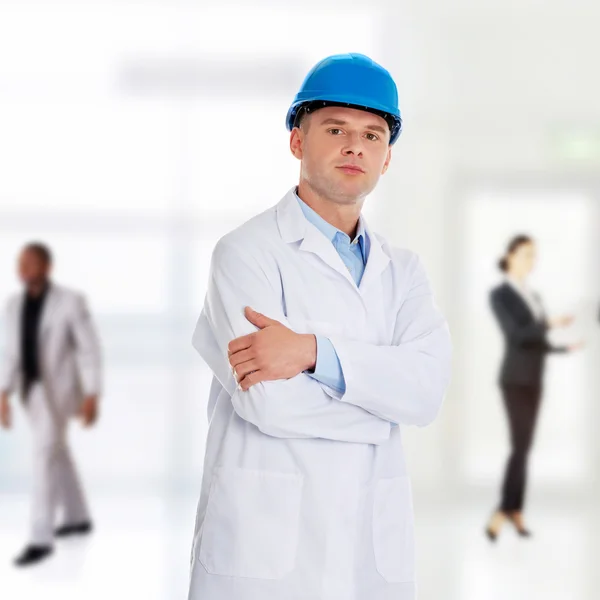 Man in a lab coat and helmet — Stock Photo, Image