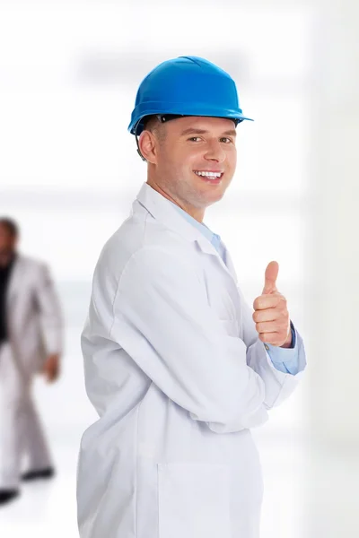 Man in een laboratoriumjas en helm — Stockfoto