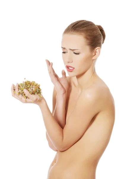 Nude woman is disgust because of sunflower sprouts — Stock Photo, Image