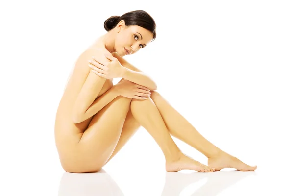 Nude woman sitting with knees close to the chest — Stock Photo, Image