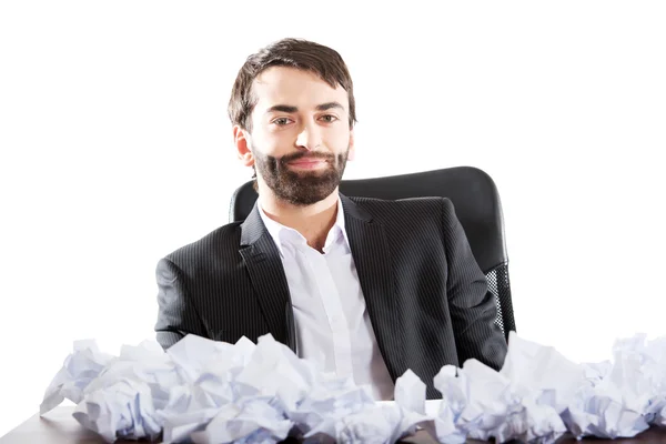 Joven hombre de negocios sentado con sábanas aplastadas . — Foto de Stock