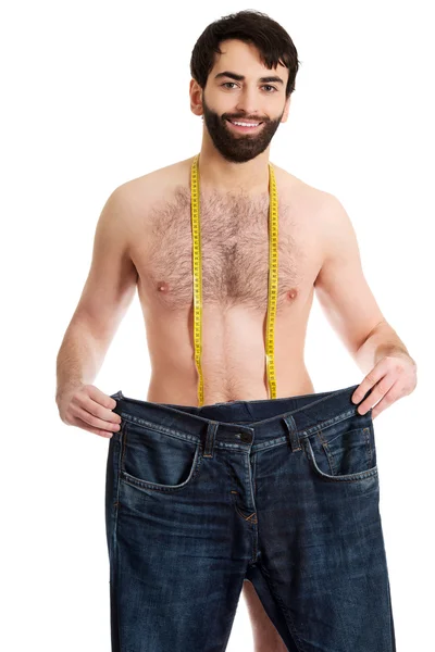 Hombre con jeans de gran tamaño y cinta métrica . —  Fotos de Stock