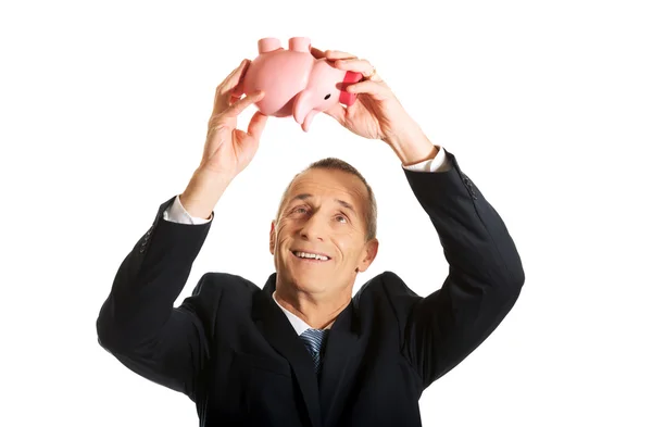 Feliz hombre de negocios sosteniendo Piggybank — Foto de Stock