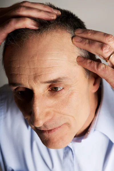 Uomo esaminando i suoi capelli — Foto Stock