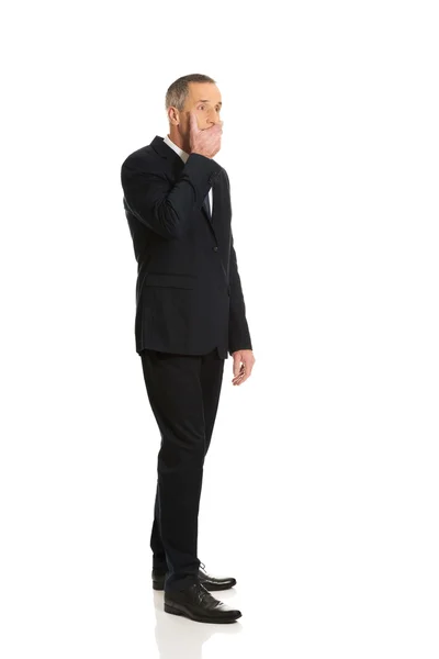 Full length businessman covering mouth — Stock Photo, Image