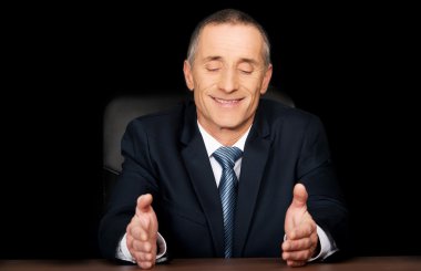 Masa başında oturan işadamı gülümseyen