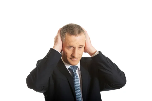 Retrato del hombre cansado cubriendo las orejas con las manos — Foto de Stock