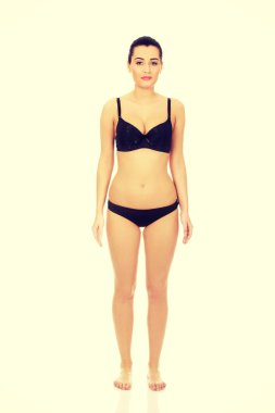 güzel bir kadın çamaşırlarıyla ayakta.