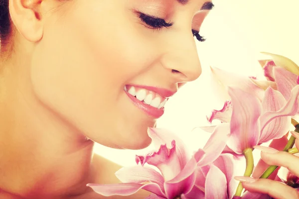 Mooie vrouw met roze bloem. — Stockfoto