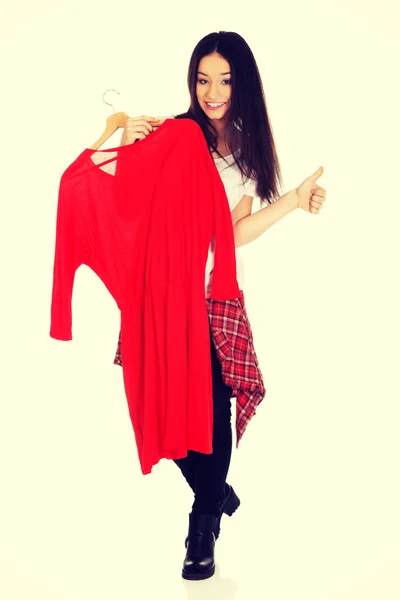 Beautiful woman holding red dress. — Stock Photo, Image