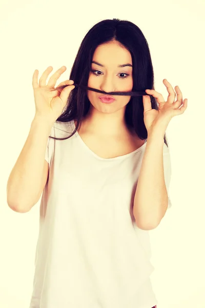 Adolescente mujer poniendo pelo como bigote . — Foto de Stock