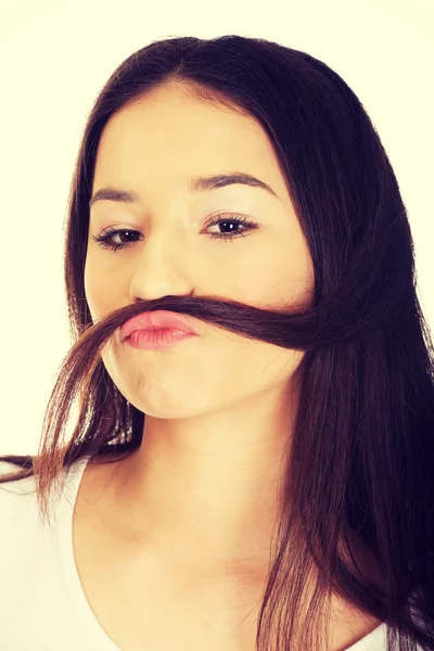 Adolescente mujer poniendo pelo como bigote . — Foto de Stock