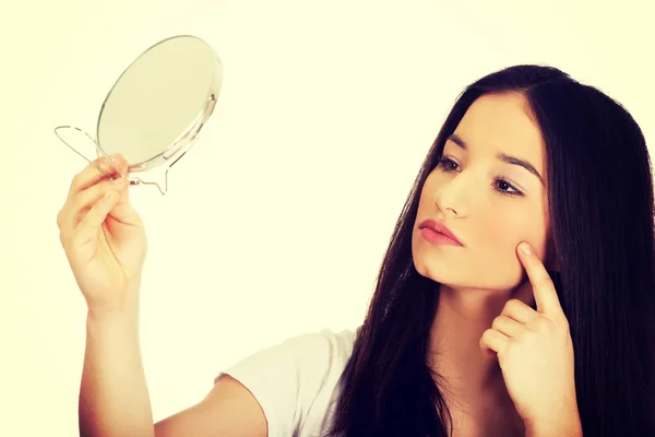 Woman with mirror checking pimples. — Stock Photo, Image