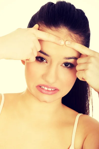 Adolescente mujer apretando espinilla . — Foto de Stock