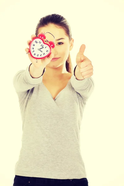 Woman with a clock and thumbs up. — Stock Photo, Image