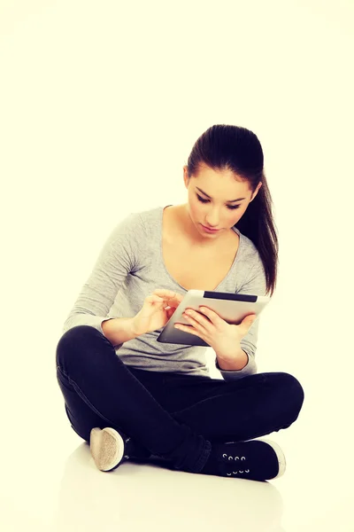 Frau mit Tablet sitzt im Schneidersitz. — Stockfoto