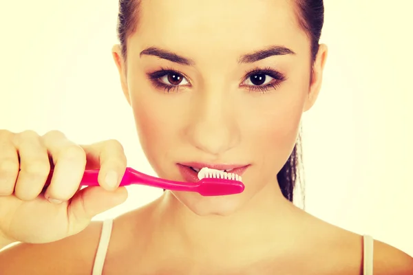 Mladá žena si čistí zuby. — Stock fotografie