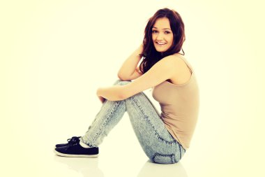 katta oturan genç gülümseyen kadın.