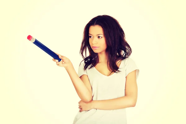 Woman pointing aside with big pencil. — Stock Photo, Image