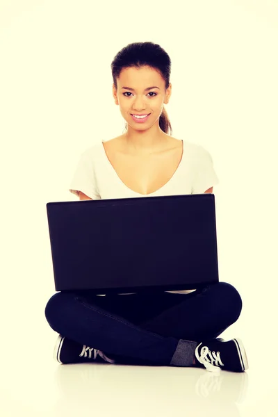 Tonåring sitter cross ben med laptop. — Stockfoto