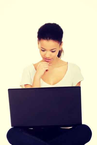 Adolescente sentado de pernas cruzadas com laptop . — Fotografia de Stock