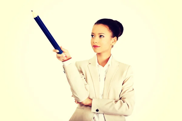 Affärskvinna pekar uppåt med stor penna. — Stockfoto