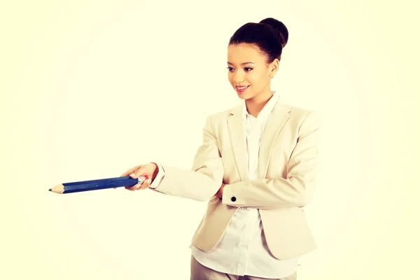 Businesswoman pointing down with big pencil. — Stock Photo, Image