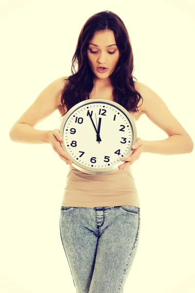 Shocked woman holding big clock. — Stock Photo, Image