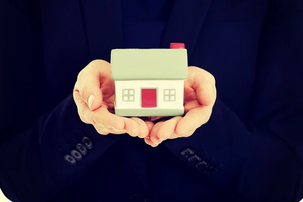 Businesswoman holding house model. — Stock Photo, Image