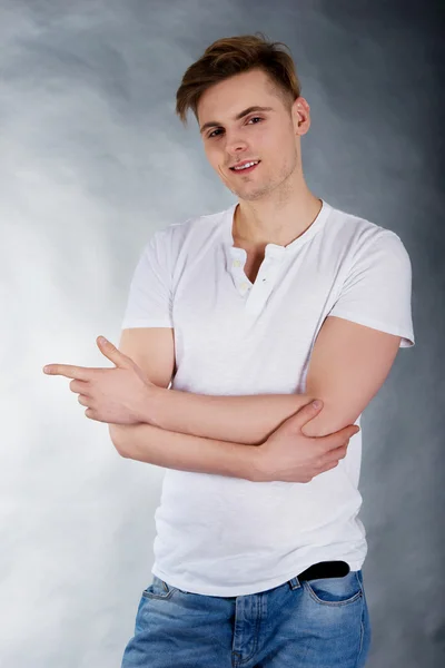 Bonito homem apontando para a esquerda . — Fotografia de Stock