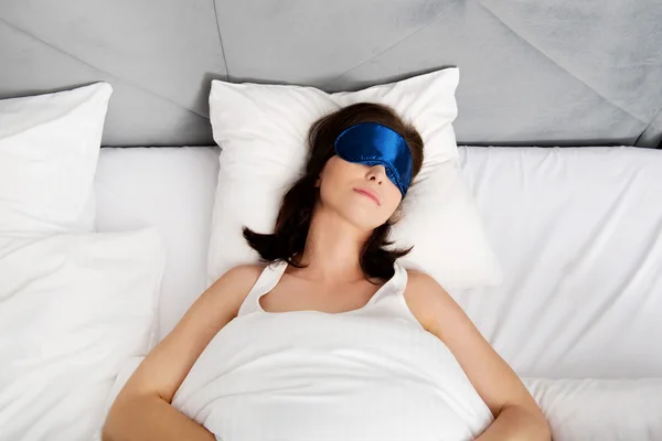 Woman sleeping in bed with eyes band. — Stock Photo, Image