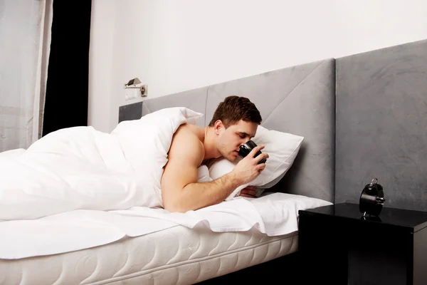 Mężczyzna w łóżku picia kawy. — Zdjęcie stockowe