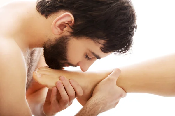 Bonito homem beijando mulheres pés . — Fotografia de Stock