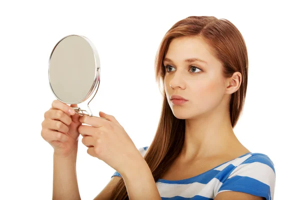 Jong mooi vrouw kijken in een spiegel — Stockfoto