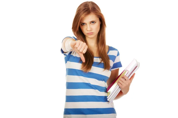 Teenage woman holding a books and shows thumb down — Stock Photo, Image