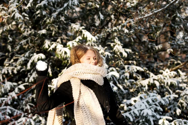 Ung kvinna kastar snöboll — Stockfoto