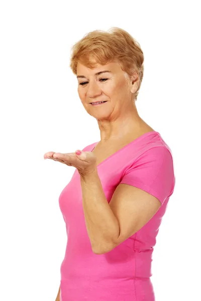 An old smiling woman presenting something — Stock Photo, Image