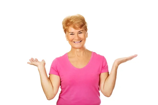 An old smiling woman presenting something — Stock Photo, Image