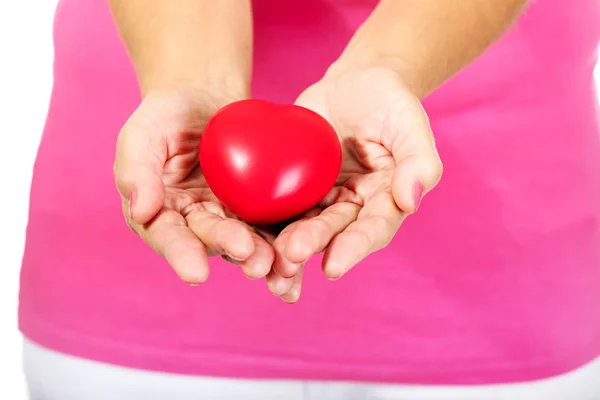 Old woman holding red toy heart — Stock Photo, Image