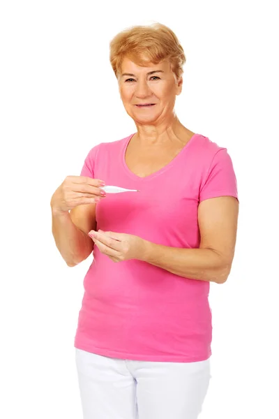 Mujer mayor sonriente sosteniendo termómetro —  Fotos de Stock