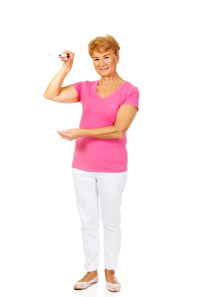 Smiling senior woman shows thermometer — Stock Photo, Image